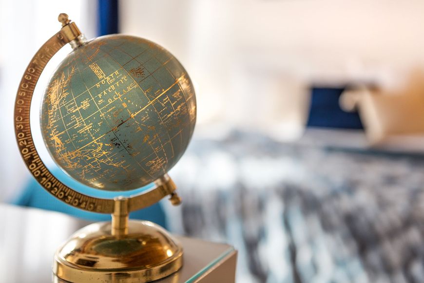 Primo piano di un piccolo mappamondo in stile vintage appoggiato su una scrivania.