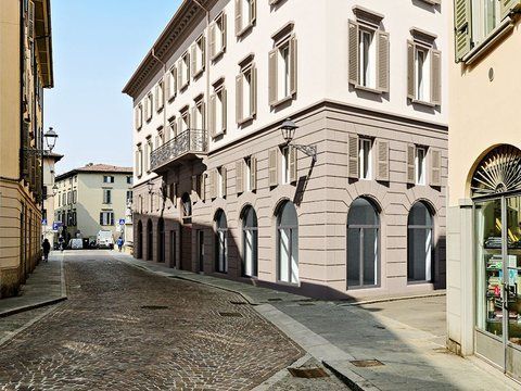 Uno scorcio dal basso di una storica torre campanaria in pietra contro un cielo azzurro e limpido.