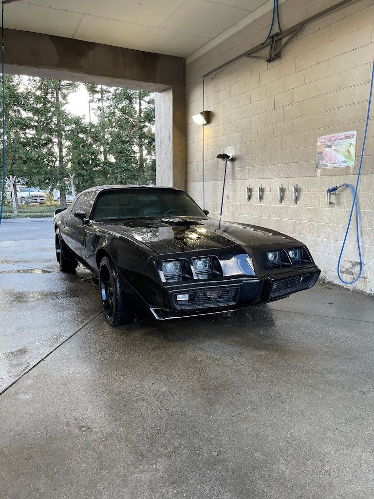 A black car is parked in a car wash.