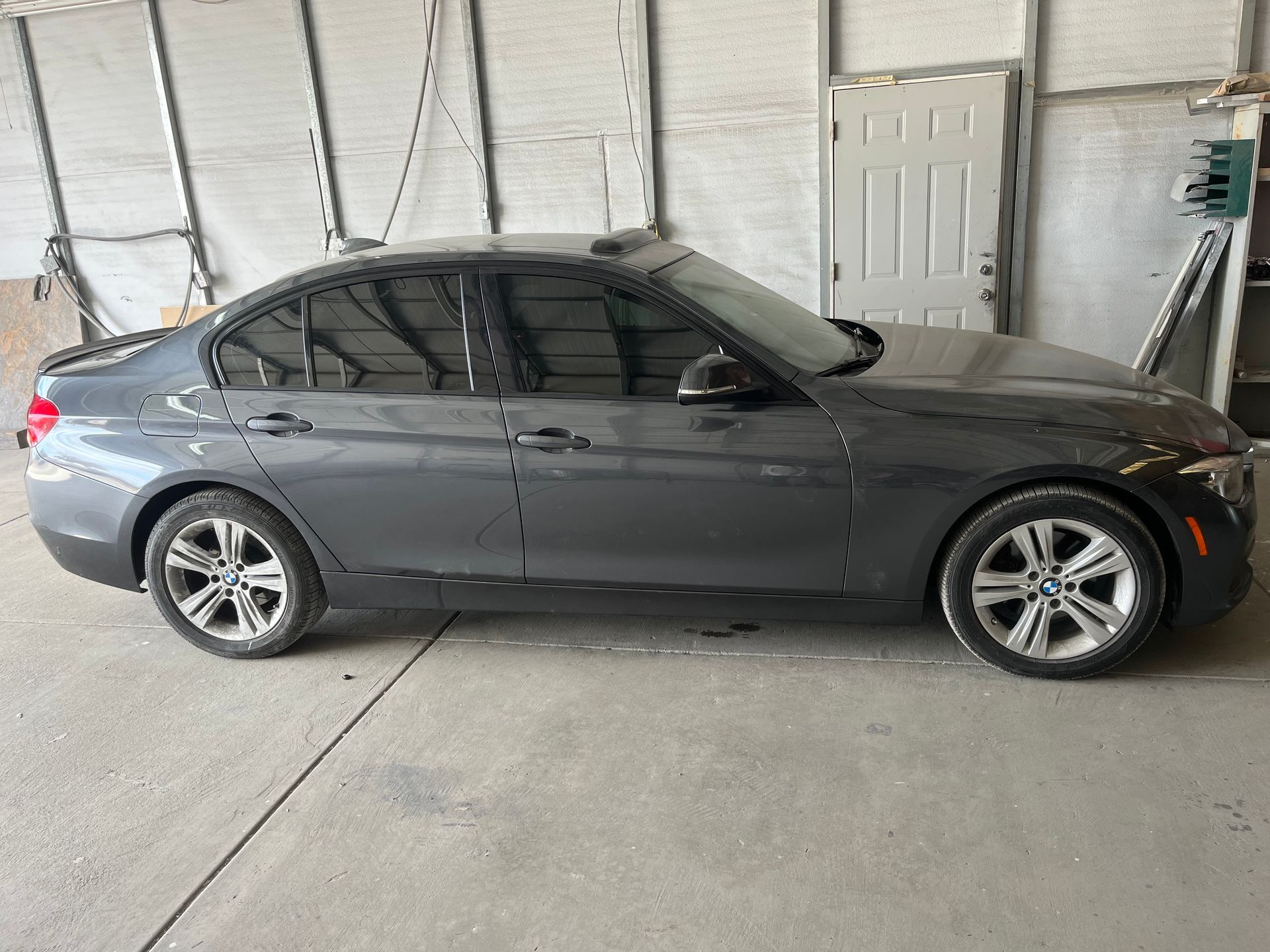 Gray BMW sedan parked inside a garage.