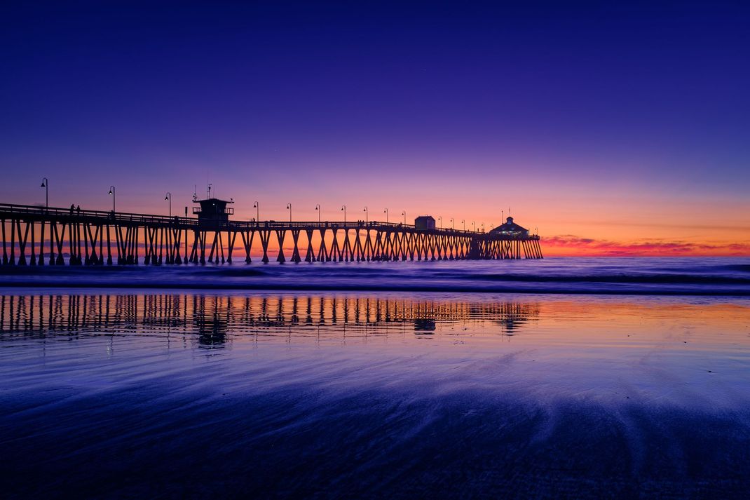 a pier with a lifeguard tower at the end of it