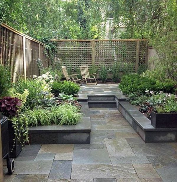 Small outdoor garden with stone tiles and outdoor seating