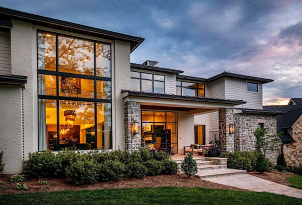 A contemporary house with large windows and two custom lamps surrounding the front door