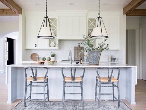 Spaced out white pendants over island