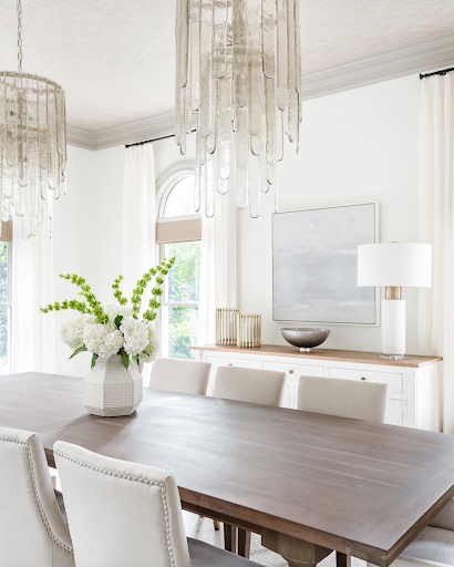 Glass chandelier hanging over dark wood table