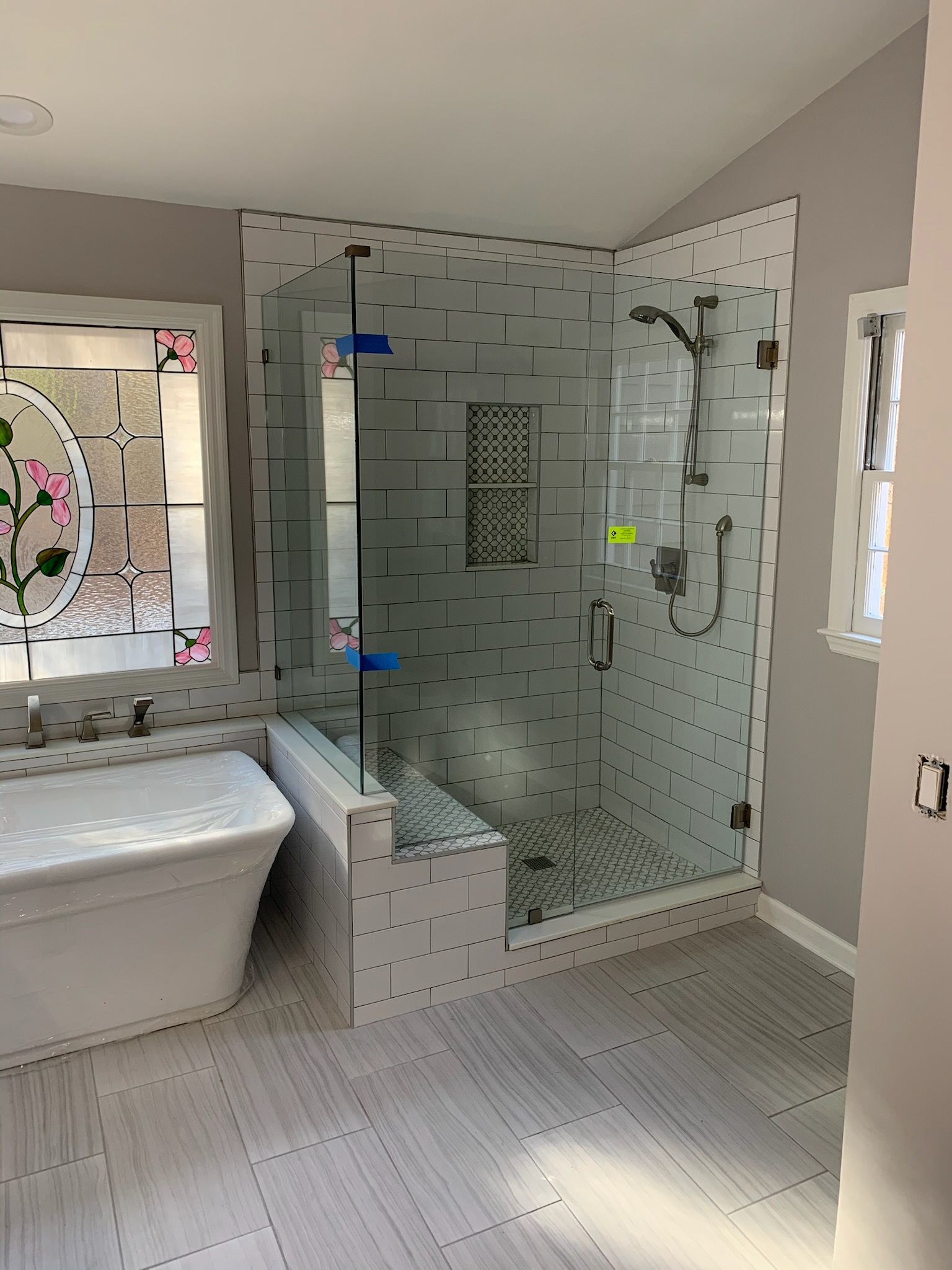 A bathroom with two sinks , a mirror , and blue cabinets.