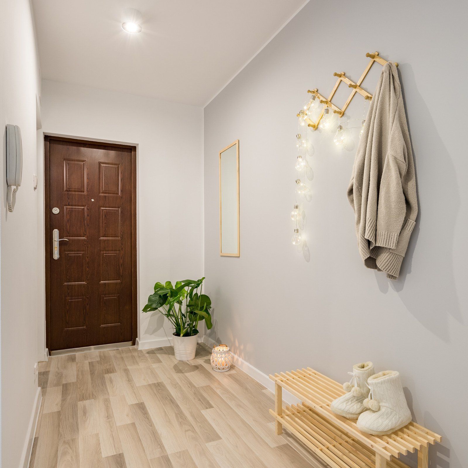 A hallway with a wooden bench and a wooden door