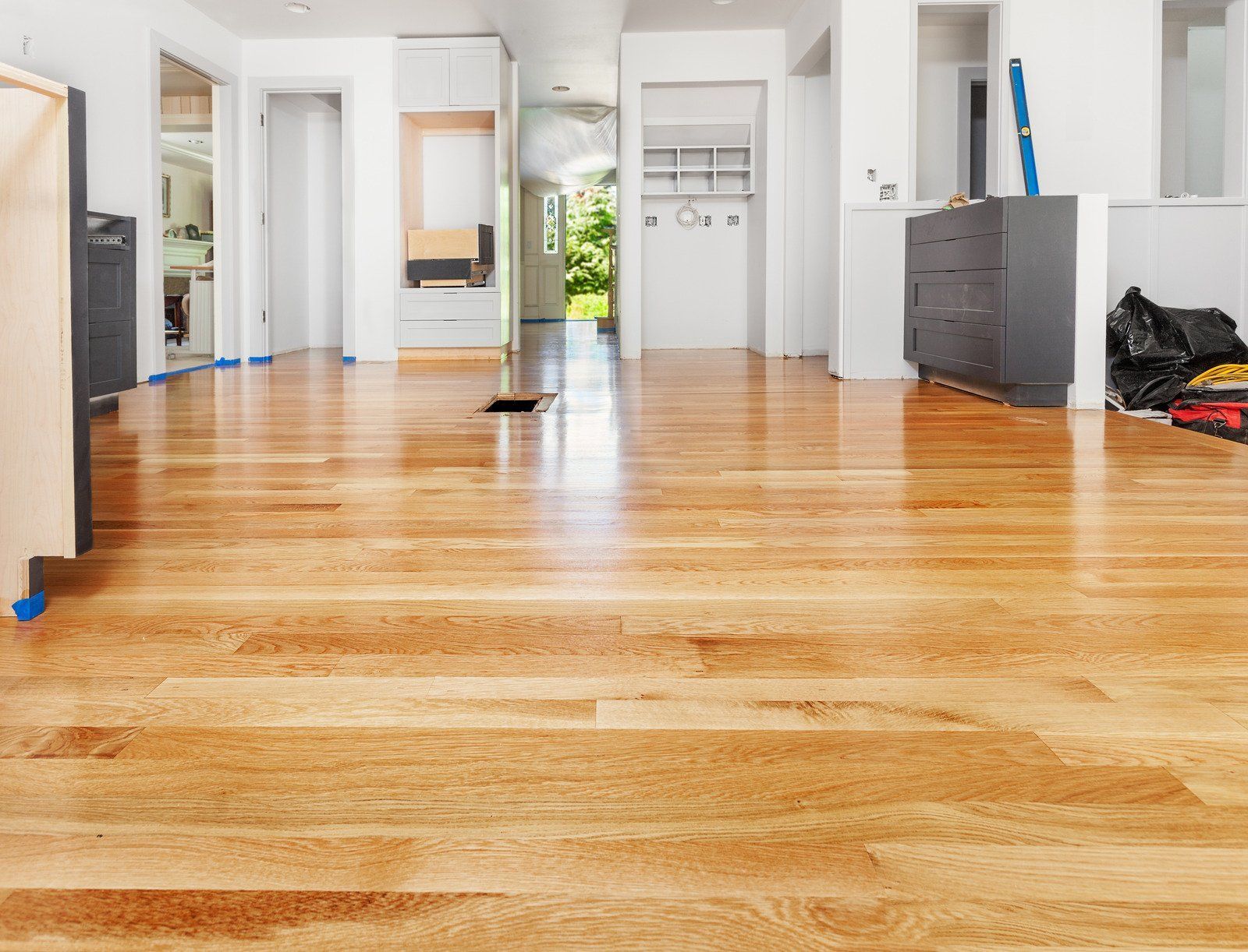 A large empty room with hardwood floors and white walls.