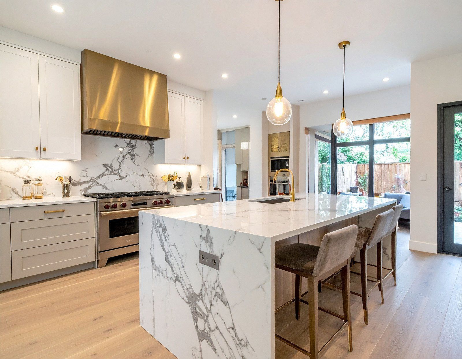 A kitchen with blue cabinets , white cabinets , stainless steel appliances and a large island.