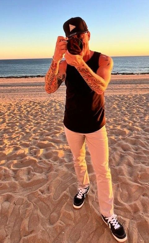 A man is taking a picture of himself on the beach.