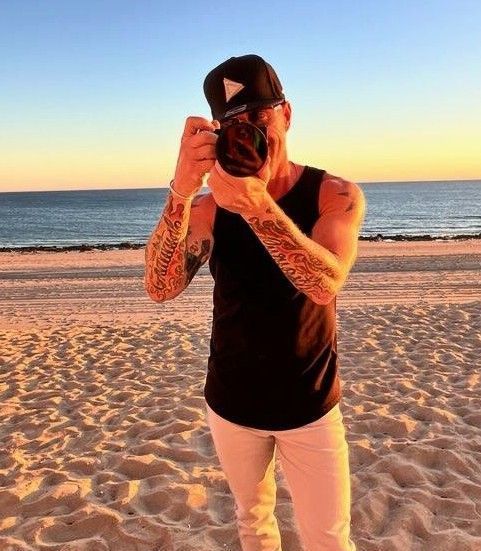 A man taking a picture of the ocean with a camera