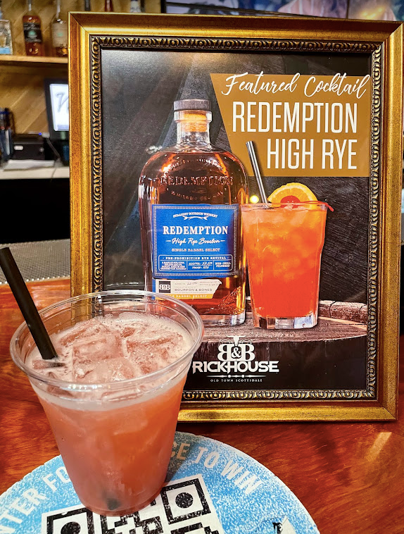 A picture of a bottle of redemption high rye next to a drink