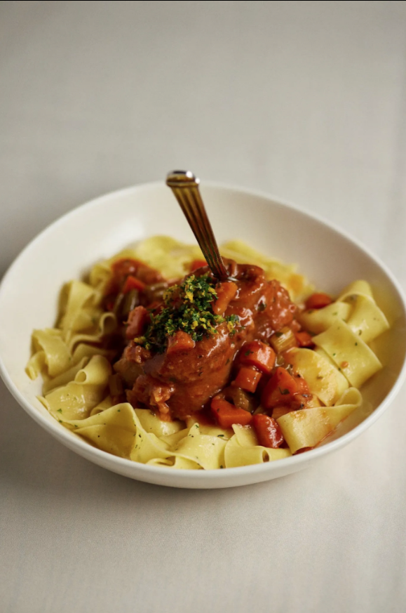 A bowl of pasta with sauce and a spoon in it
