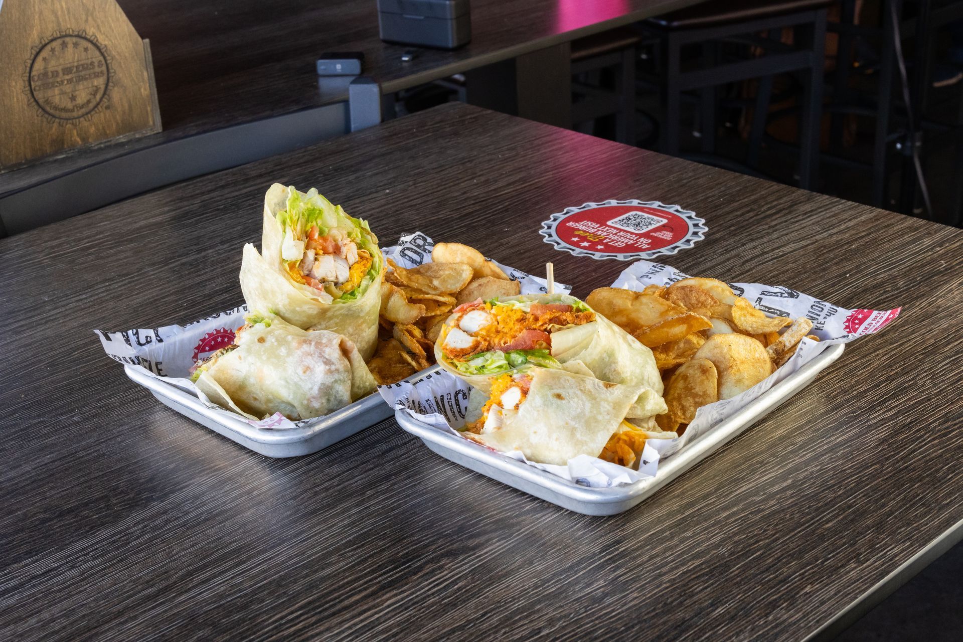 Two plates of food are sitting on a wooden table.