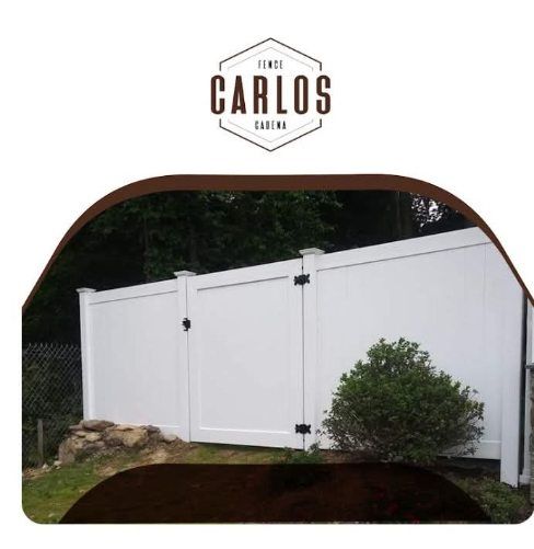 White vinyl fence with gate in front of trees, with 