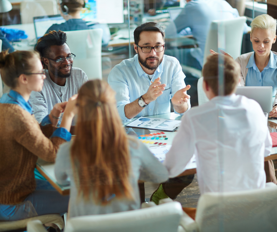 A group of people are sitting around a table having a meeting.