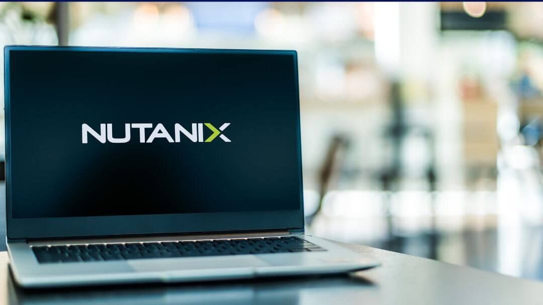 A laptop computer is sitting on a table with the nutanix logo on the screen.