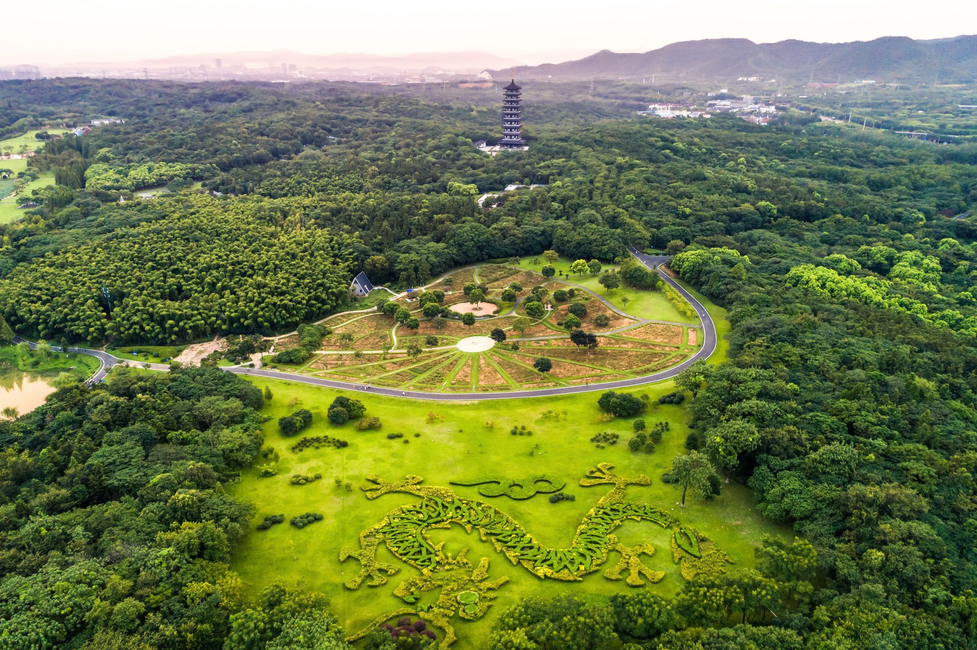 An aerial view of a lush green forest with a tower in the distance.