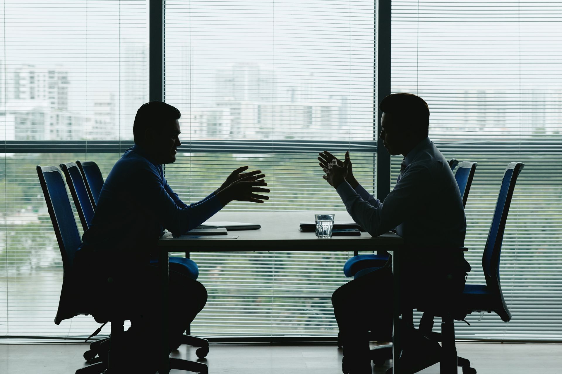 Two men are sitting at a table having a conversation.