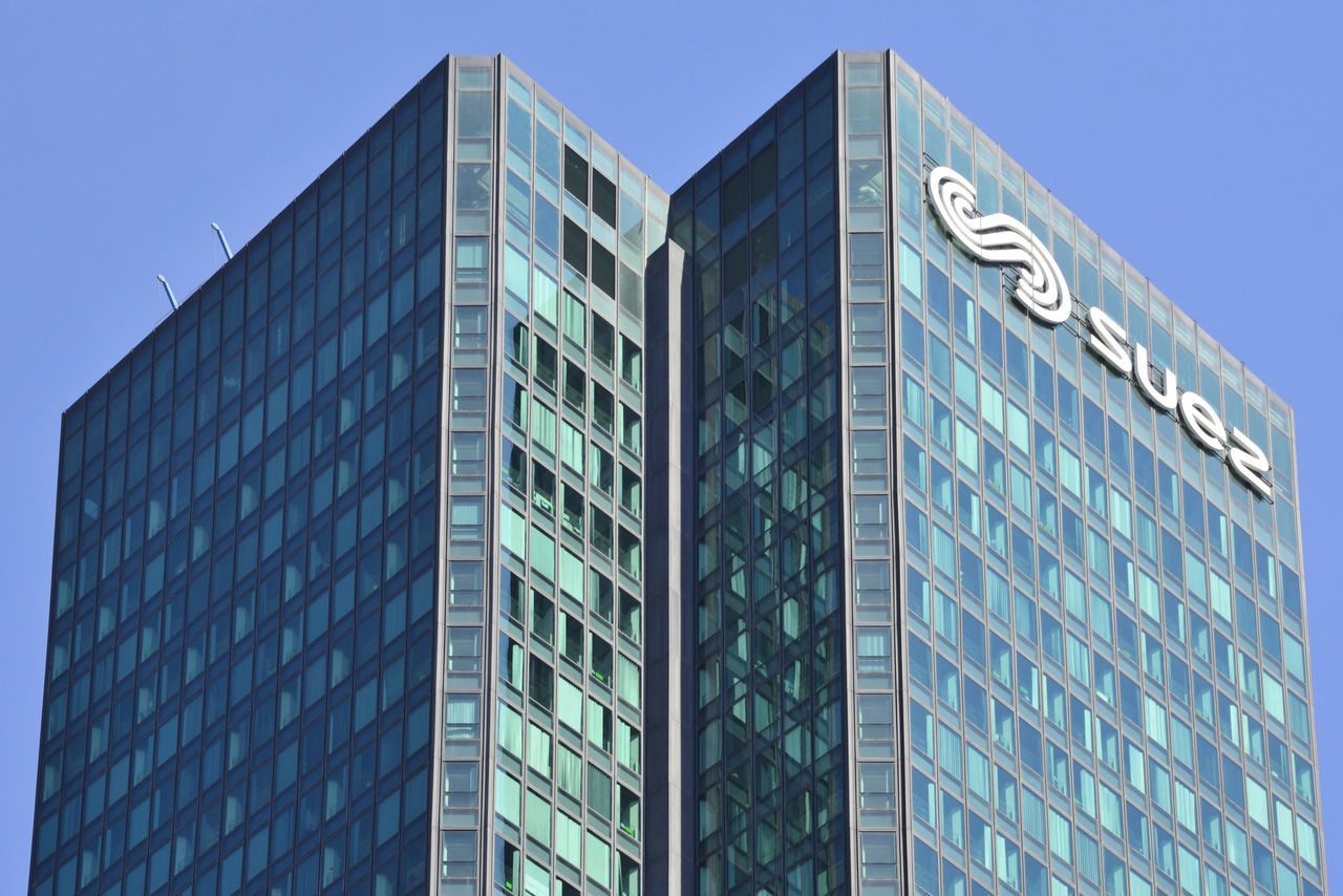 A very tall building with the word suez on it