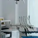 Smiling patient in a dental chair with a blue bib and green headrest