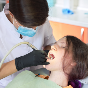 Dentist using a drill on a patient in a dental clinic