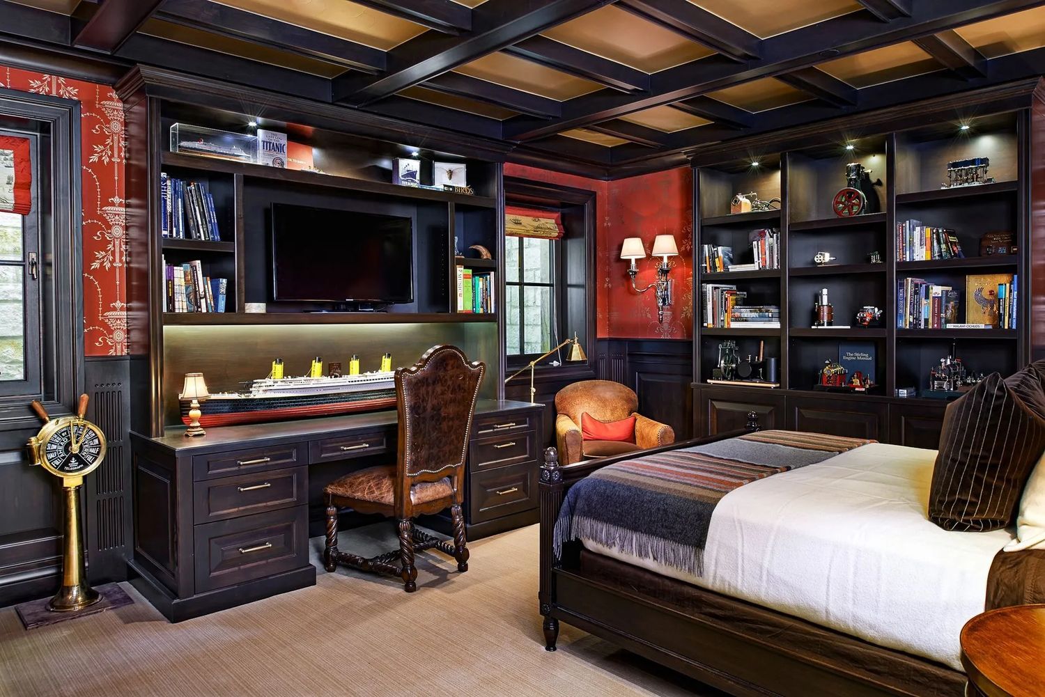 Dark-toned bedroom with built-in desk, bookshelves, TV, and bed. Red accent walls, beige carpet, and decorative clock.