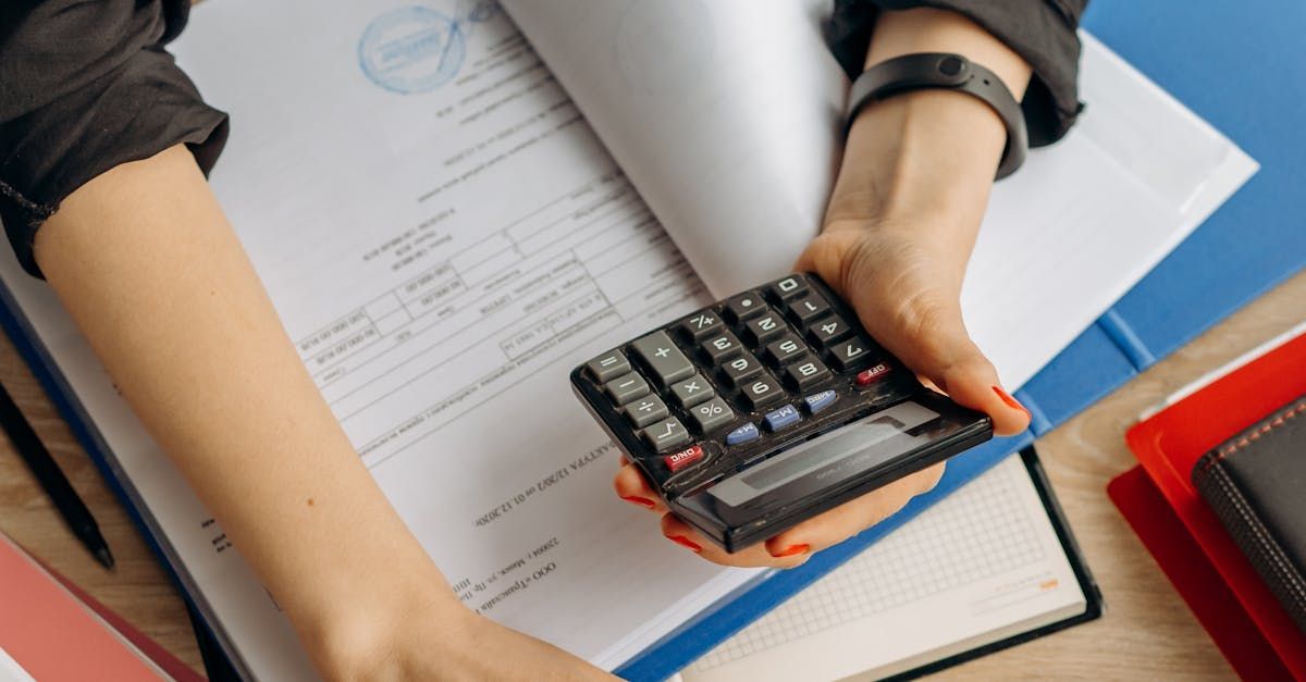 A woman is holding a calculator in front of a book.