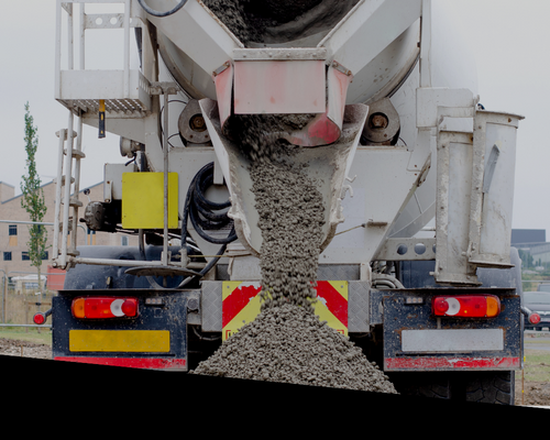 Concrete mixer truck pouring wet concrete from the rear chute onto the road