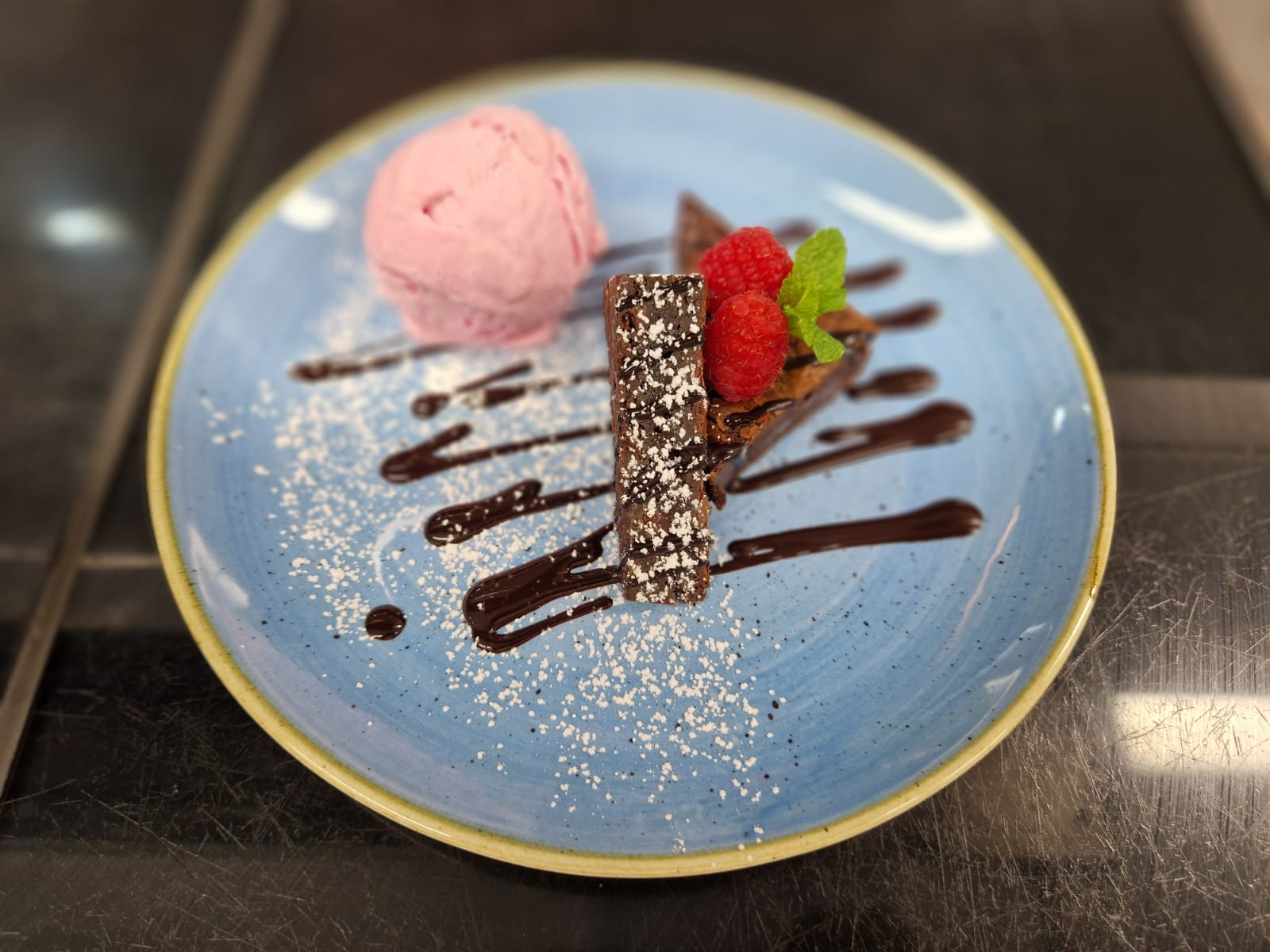 Beautifully plated chocolate dessert with raspberries, mint and ice cream, showcasing the quality, attention to detail and high standards a reliable contract caterer brings beyond common outsourcing myths.