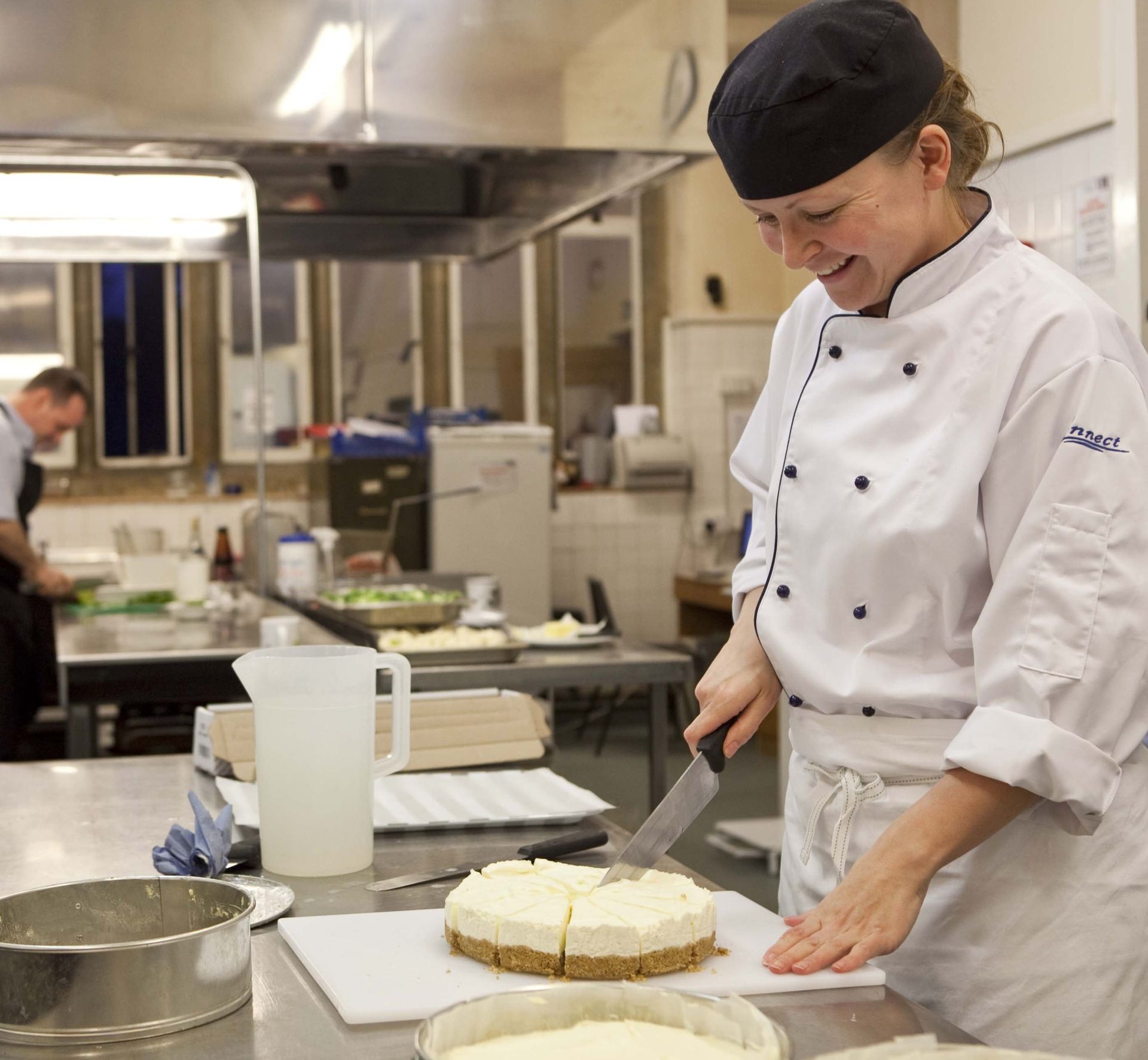 Chef preparing dessert in professional kitchen, highlighting expertise in contract catering
