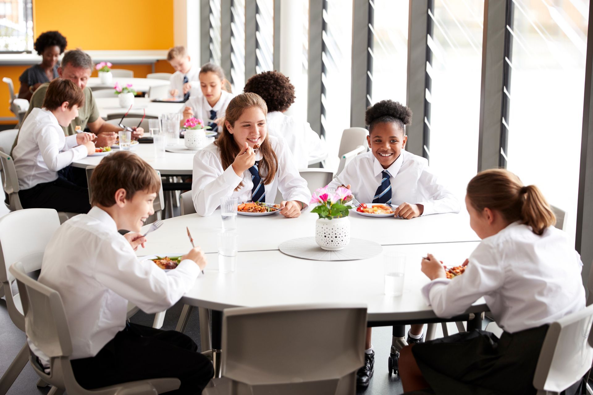 School pupils enjoying a healthy lunch together in a bright, welcoming dining hall.