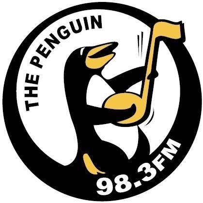 The Penguin 98.3 FM logo with a cartoon penguin holding a yellow flag
