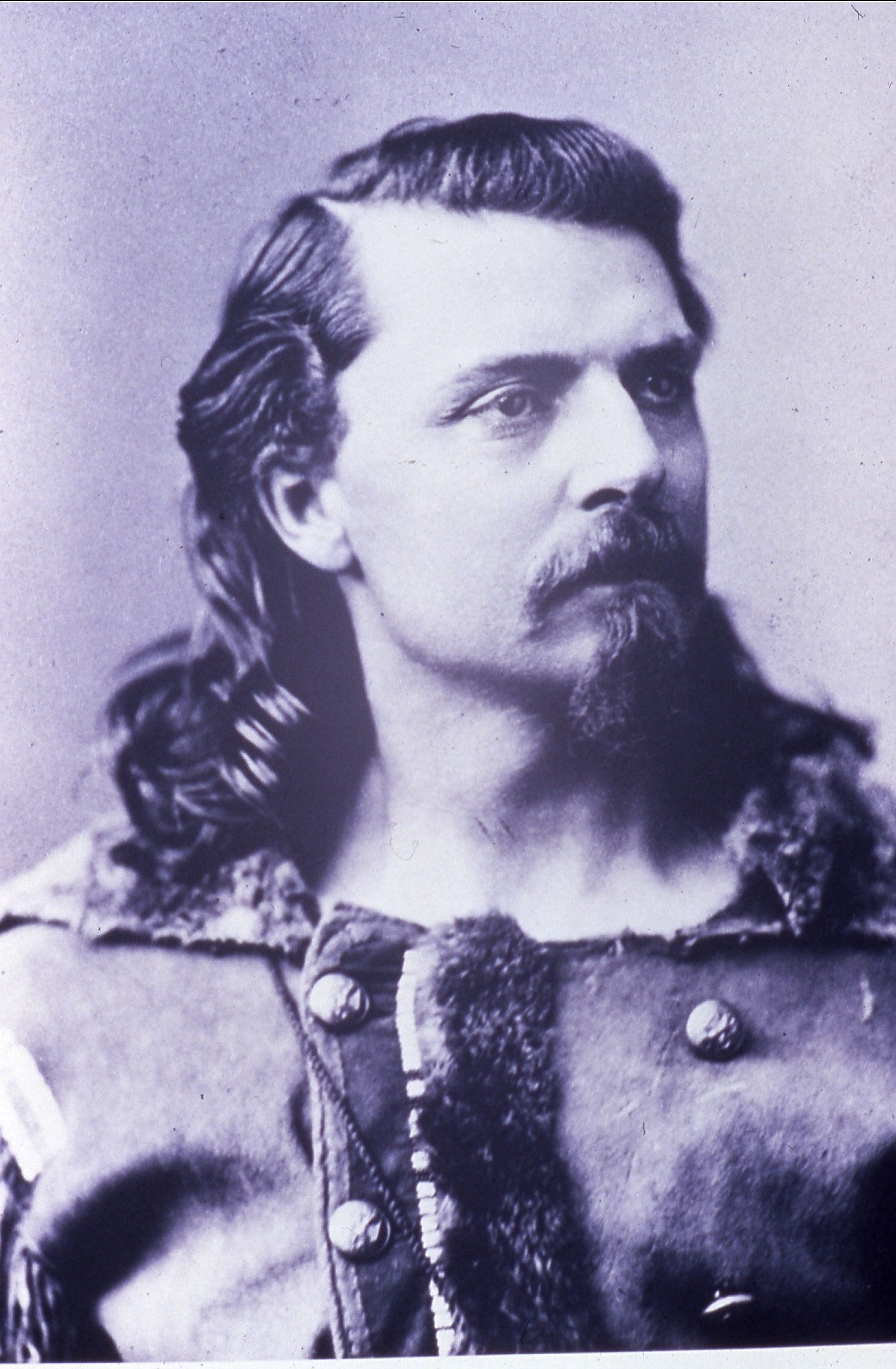 Portrait of a man with long hair and mustache in a fur-trimmed coat, looking left.