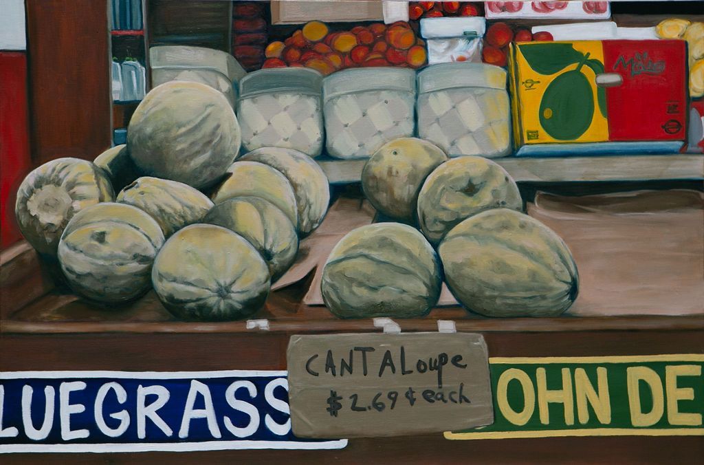 Melons stacked at a market stall with a sign reading “Cantaloupe” and price labels