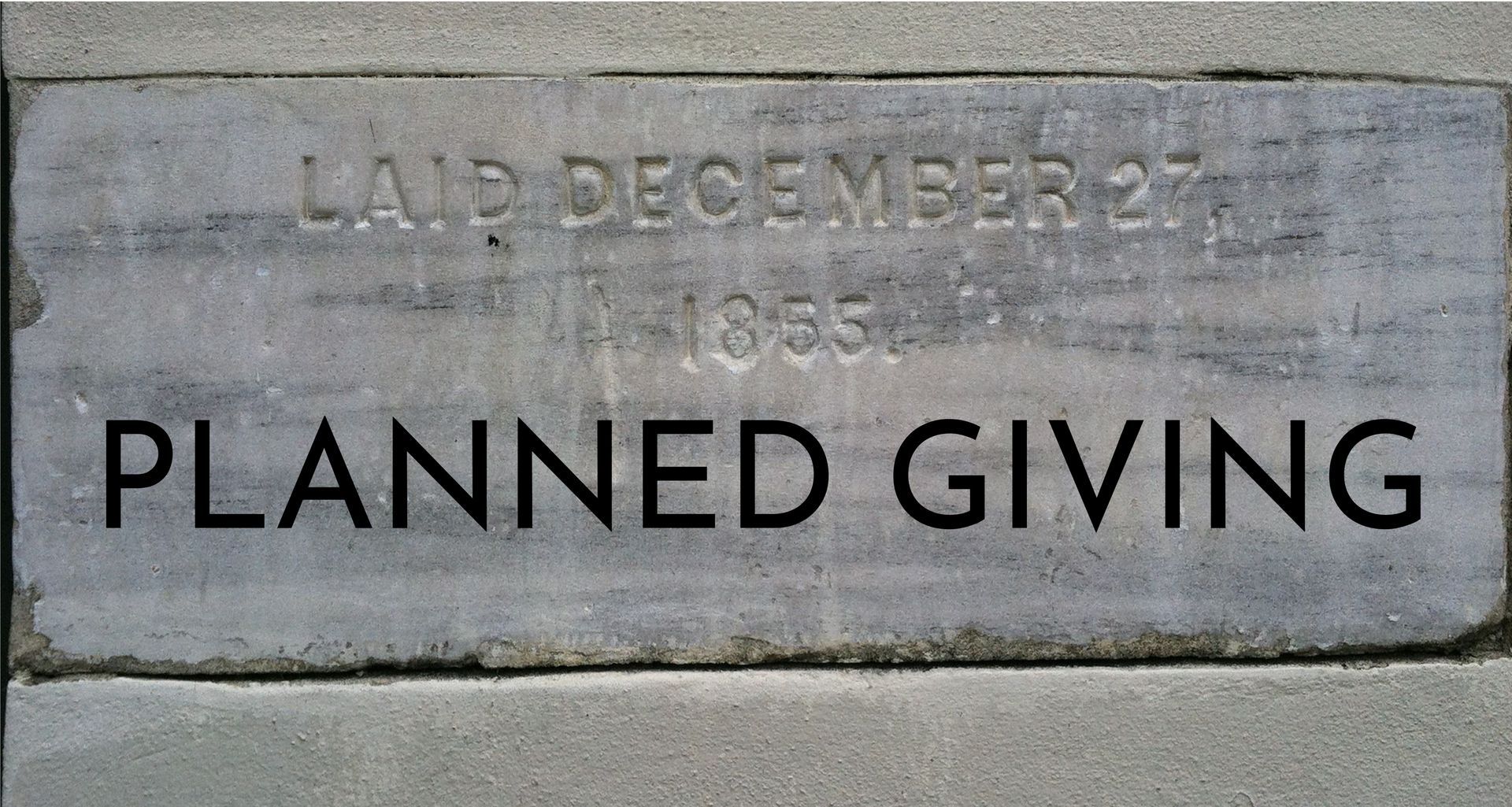Concrete plaque reading “PLANNED GIVING” with faint engraved date above.