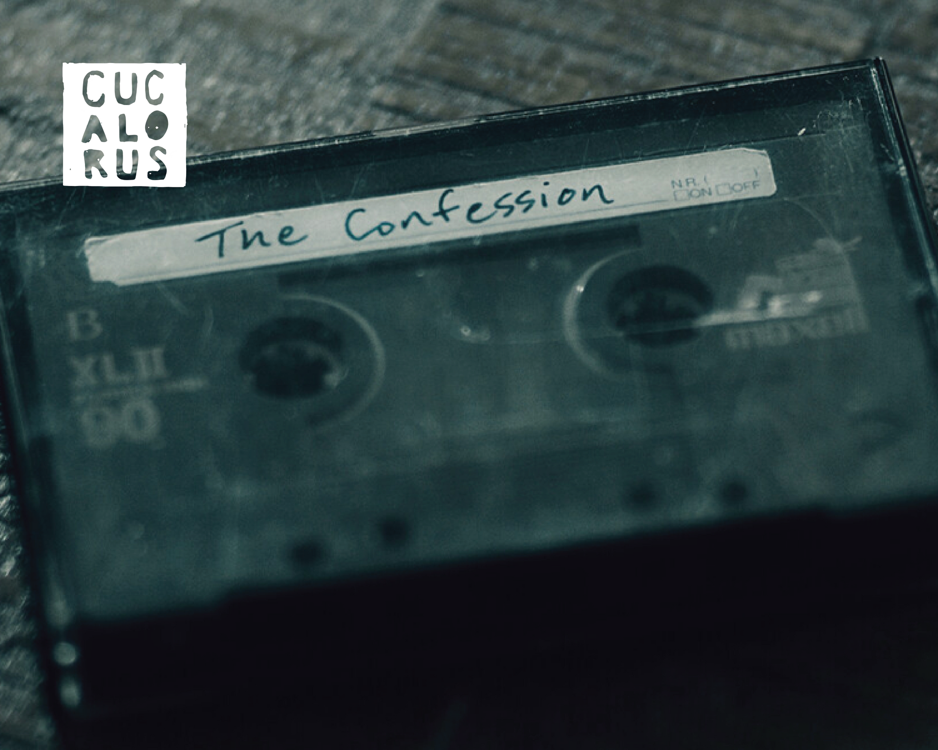 Close-up of a dark cassette tape labeled “The Confession.”