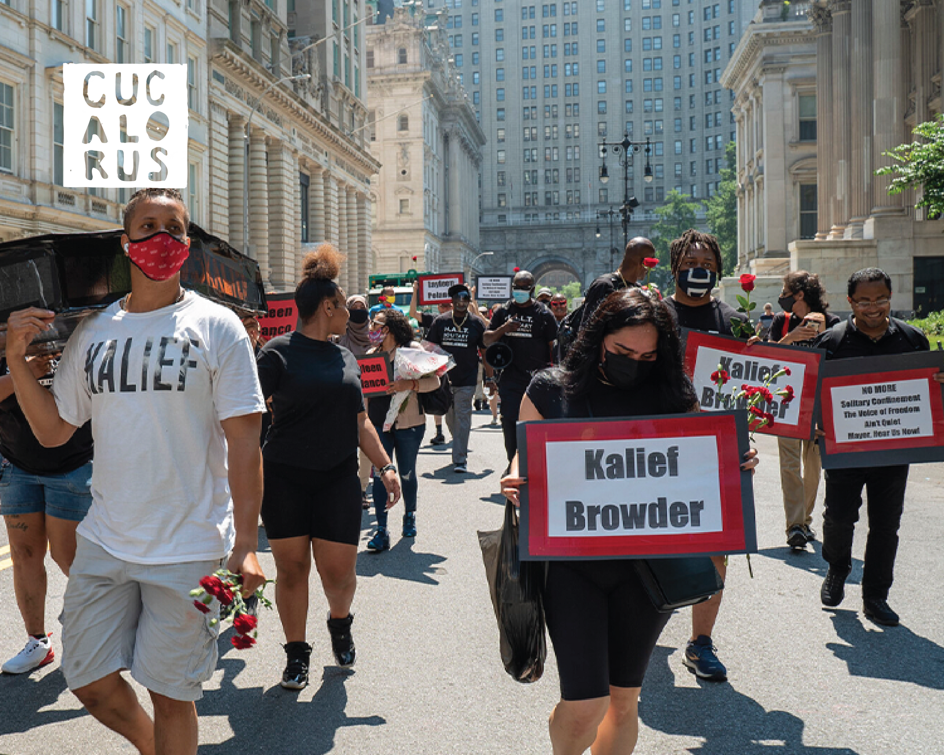 Protesters march down a city street holding signs, including one reading “Khalil Browder.”
