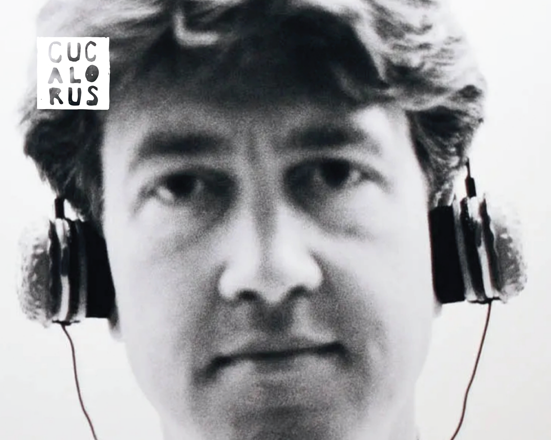 Black-and-white close-up of a man wearing headphones, with a small “CUC AL RUS” label in the corner.