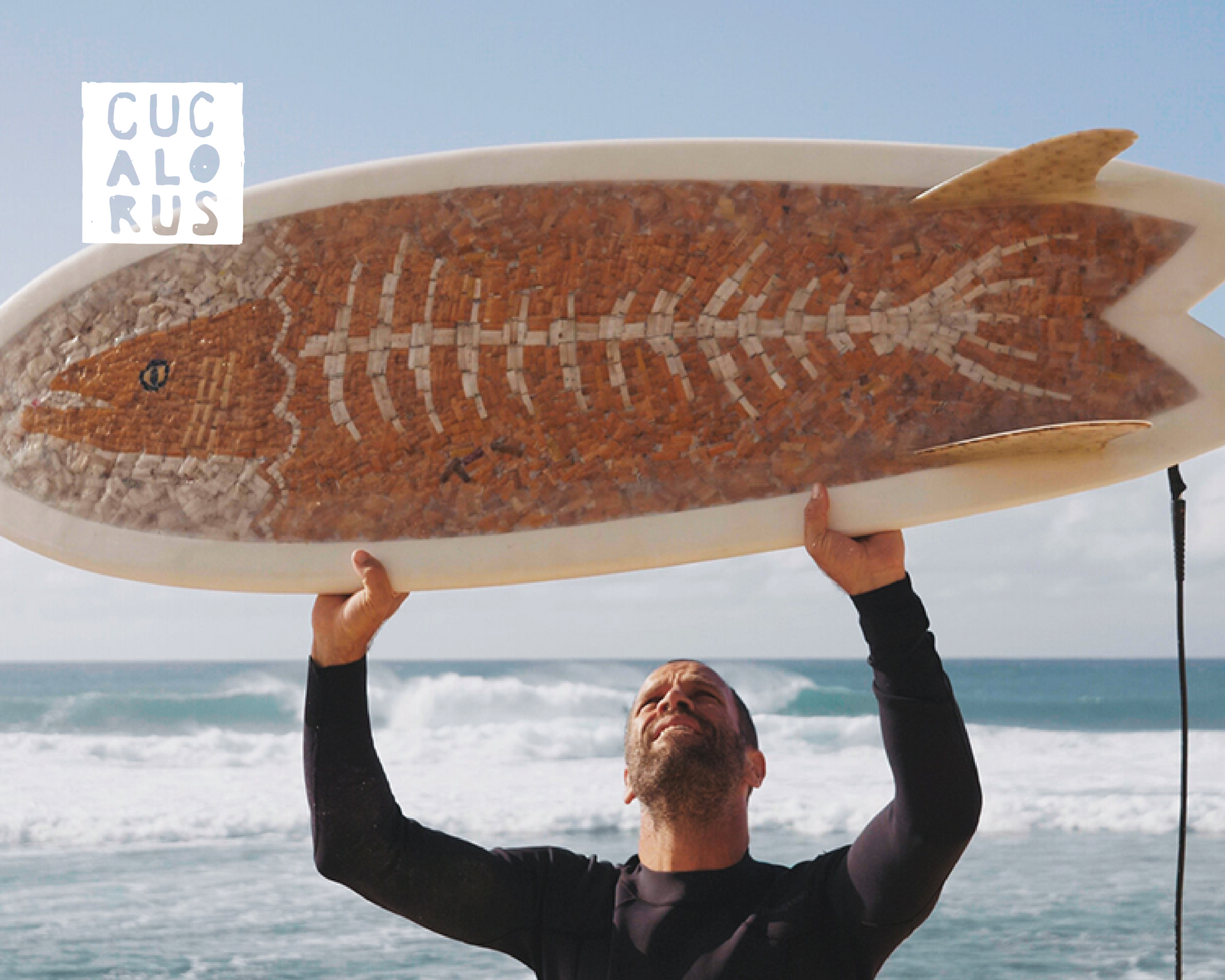 Man holding a long surfboard overhead on a beach with ocean waves in the background