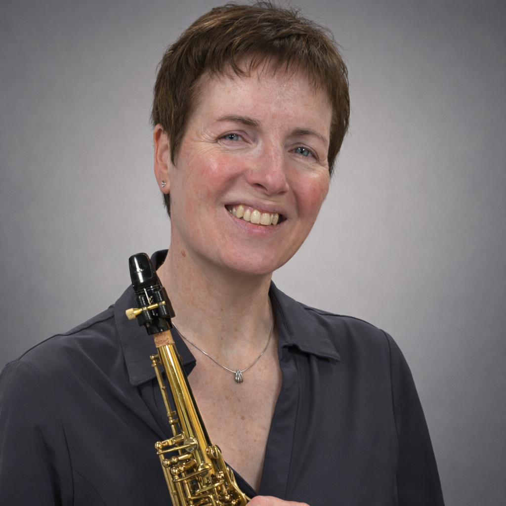 Vrouw met een saxofoon in haar handen, lachend tegen een grijze achtergrond.