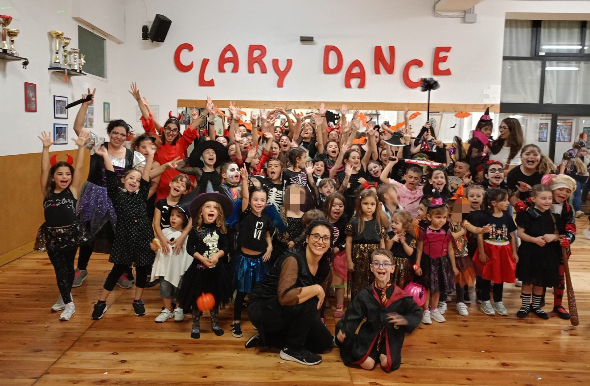 Gruppo di bambini e adulti in costume in una sala da ballo, con la scritta