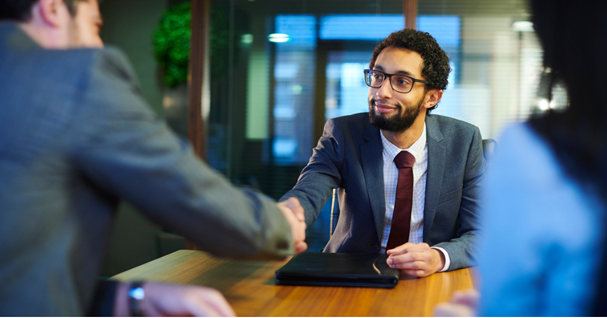 Two corporate people shaking hands in an office