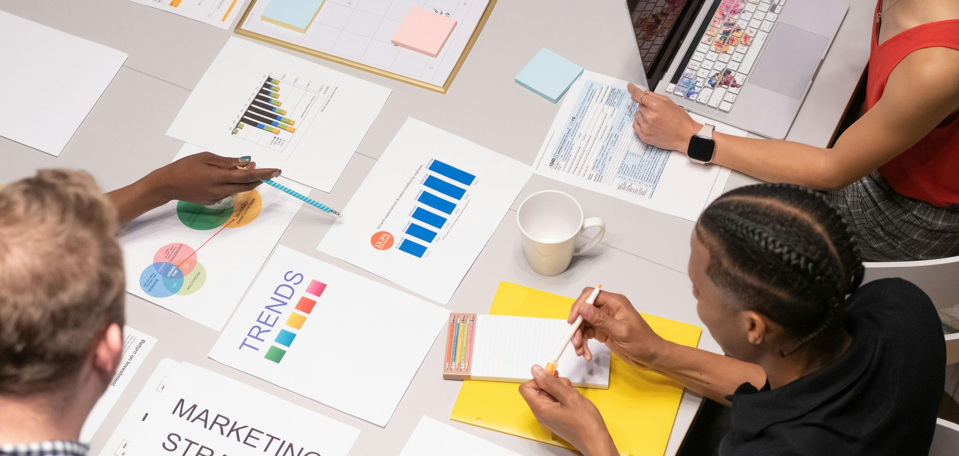 Colleagues sitting at a table discussing graphs and charts
