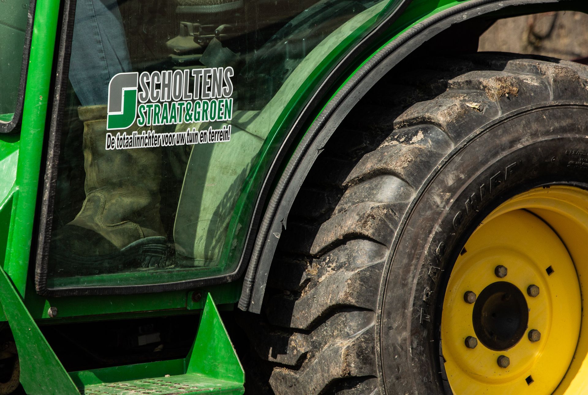 Een groene tractor met een sticker aan de zijkant waarop psycho tech staat
