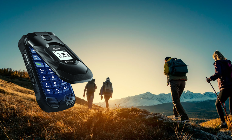 A group of people are hiking up a hill next to a cell phone.