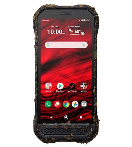 A dirty cell phone is sitting on a white surface.