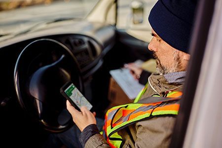 A man is sitting in a car using a cell phone.