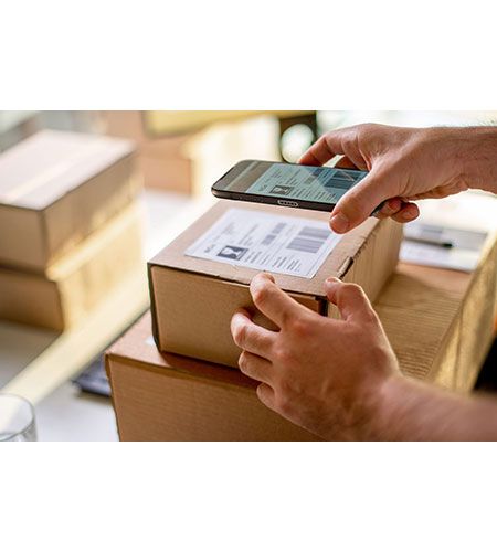 A person is using a cell phone to scan a box.
