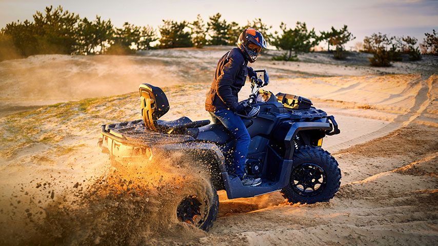 A man is riding an atv on a dirt road.